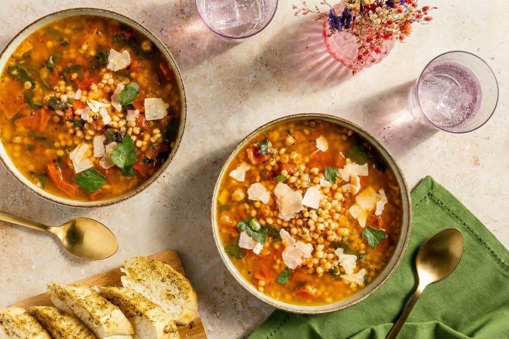 Italienische Minestrone mit fruchtiger Tomate serviert mit Käse und Knoblauchbrot