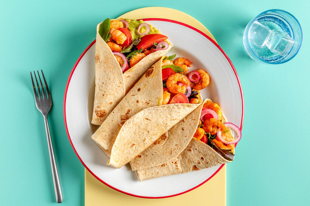 Bunte Garnelen-Tacos mit Guacamole mit frischen Tomaten und eingelegten Zwiebeln