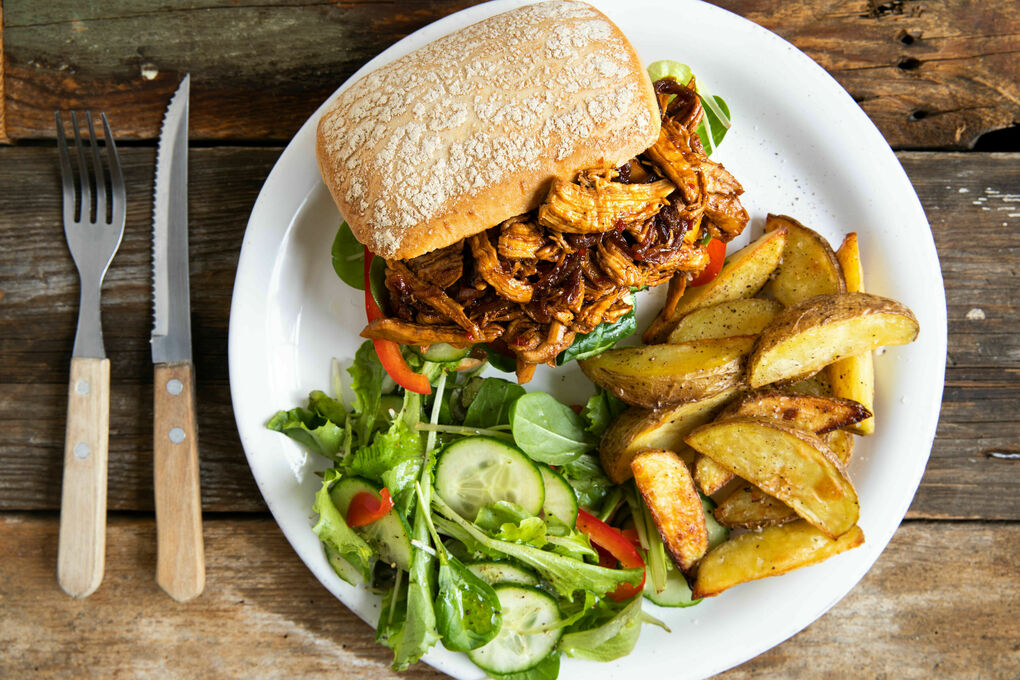 Hähnchensandwich surinamische Art mit Ofenkartoffeln und Salat