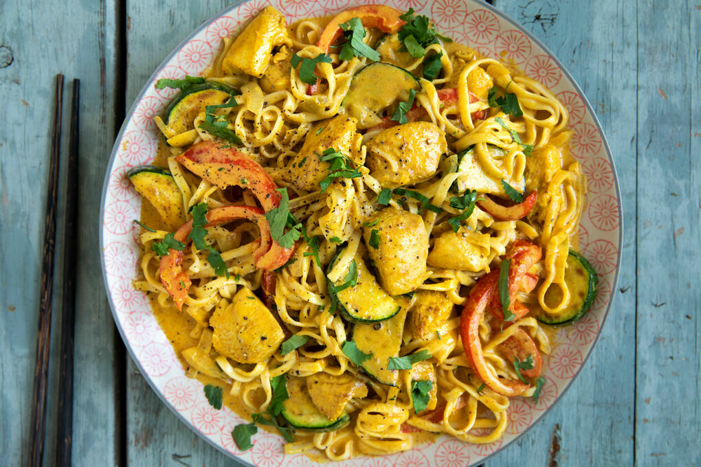 Thai-Nudelpfanne mit Hähnchen und gelber Kokosmilchsauce mit Gemüse