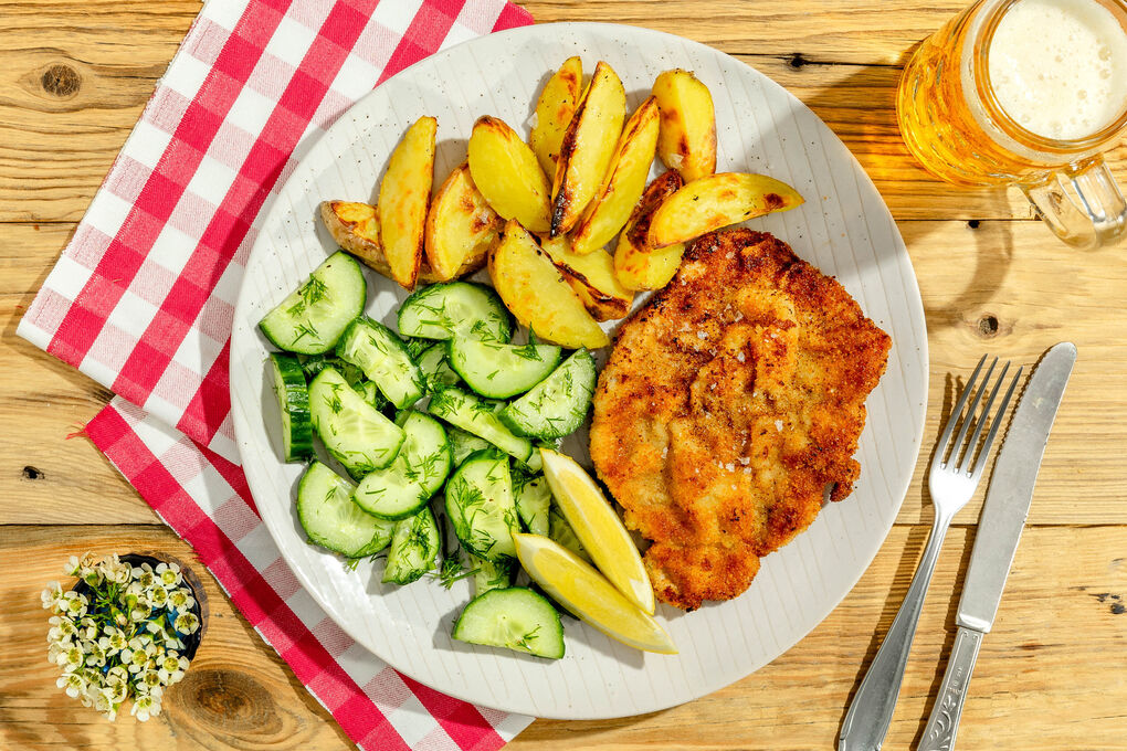 Schnitzel Wiener Art mit Gurkensalat und Backkartoffeln