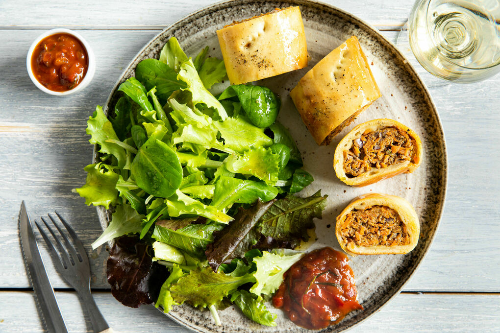 Hackfleisch-Flammkuchenrolle mit Tomaten-Zwiebel-Sauce und Salat