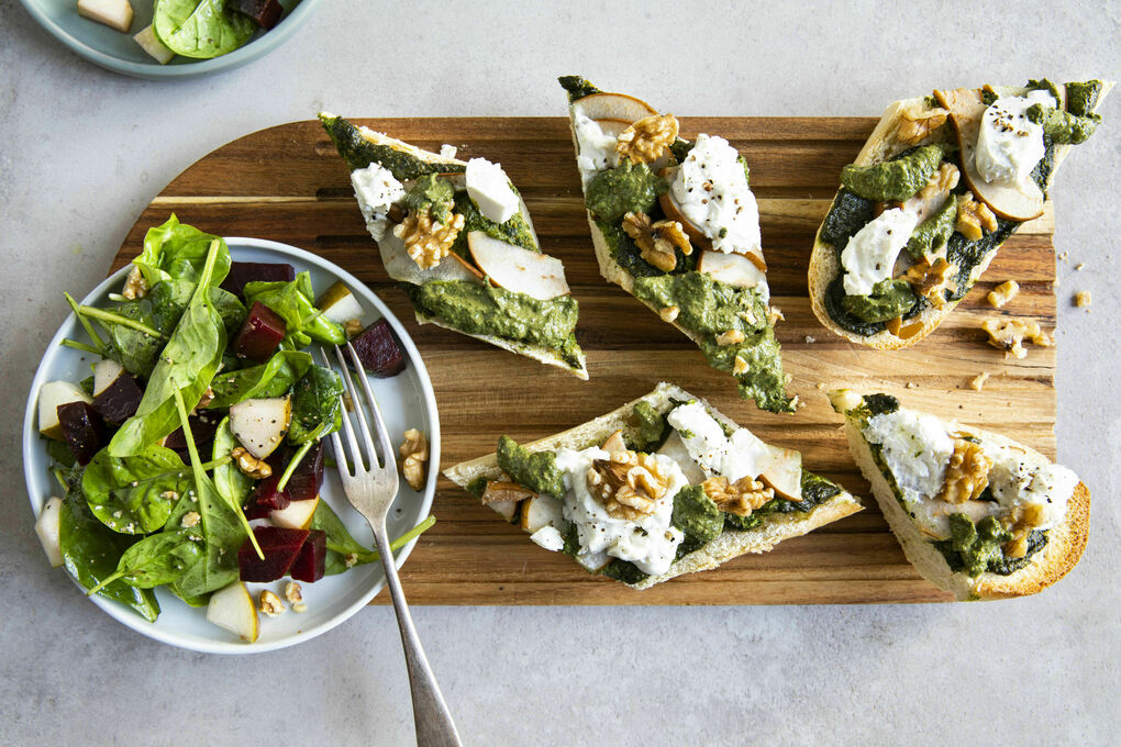 Überbackenes Ziegenkäse-Baguette mit Birne und Pesto, dazu Spinatsalat