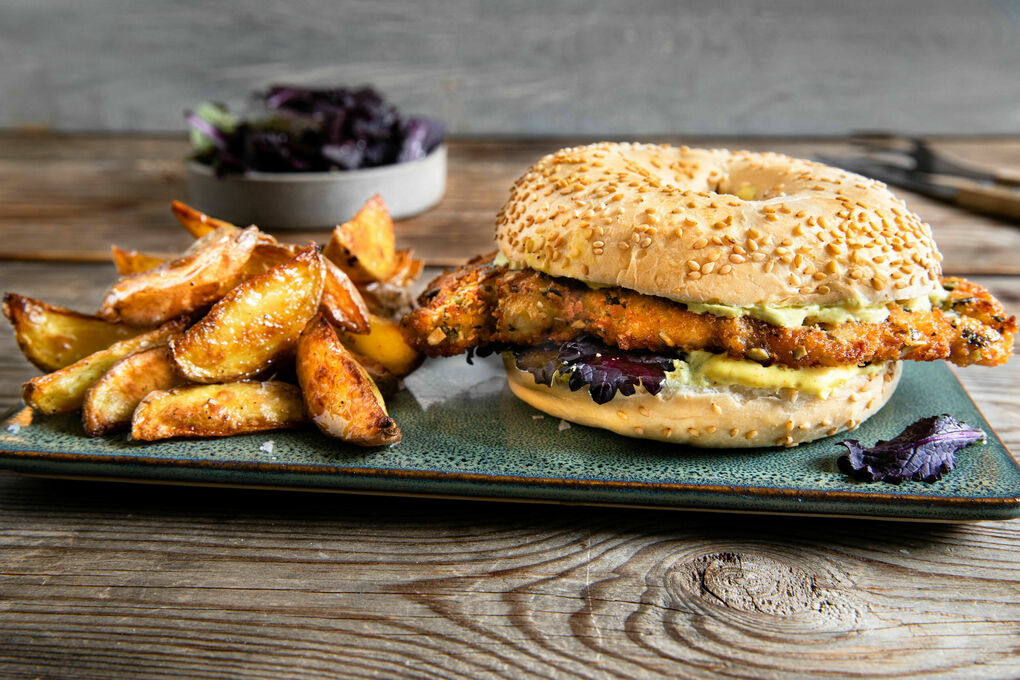 Bagel mit Hähnchenschnitzel dazu Ofenkartoffeln, Blattsenfsalat und Dip