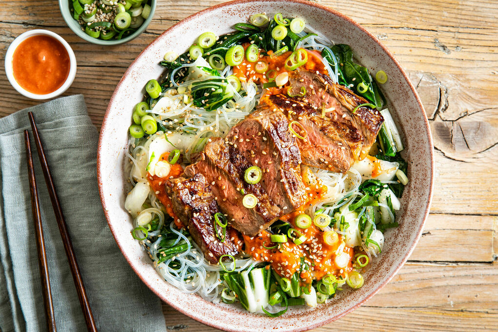Rindersteak mit pikanter Tomatensauce auf Glasnudeln mit Pak Choi und Sesam