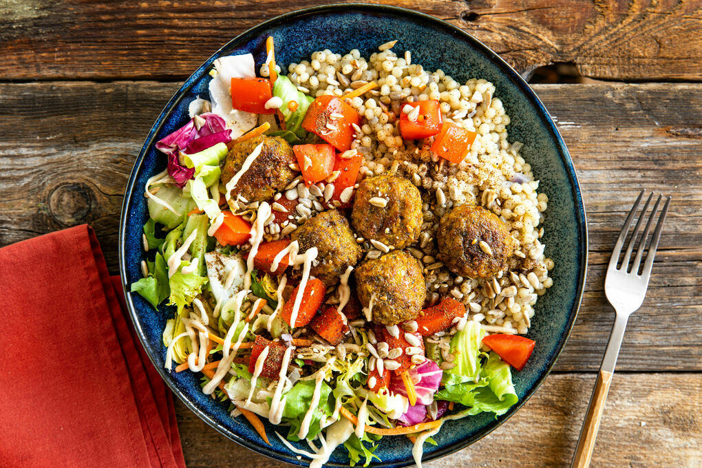 Falafeln mit cremiger Tahinisauce auf Perlencouscous und Salat