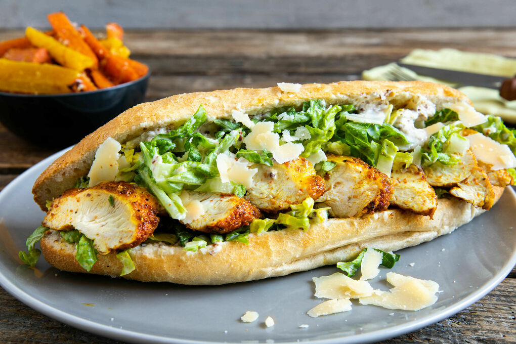 Hähnchensandwich mit Caesar-Salat dazu Karottenpommes mit Käse