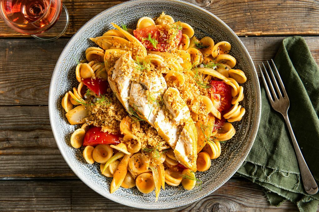 Gebratenes Hähnchen mit Bröseltopping auf Pasta mit cremiger Fenchel-Tomaten-Sauce