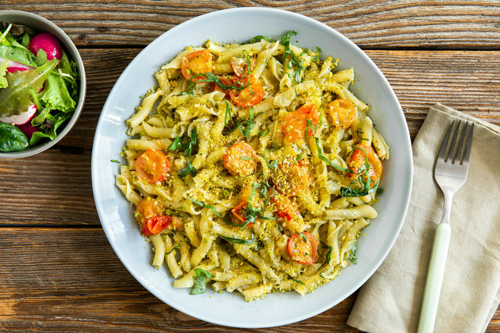 Pasta mit Kirschtomaten und Kapernpesto dazu Panko-Pistazien-Topping und Salat
