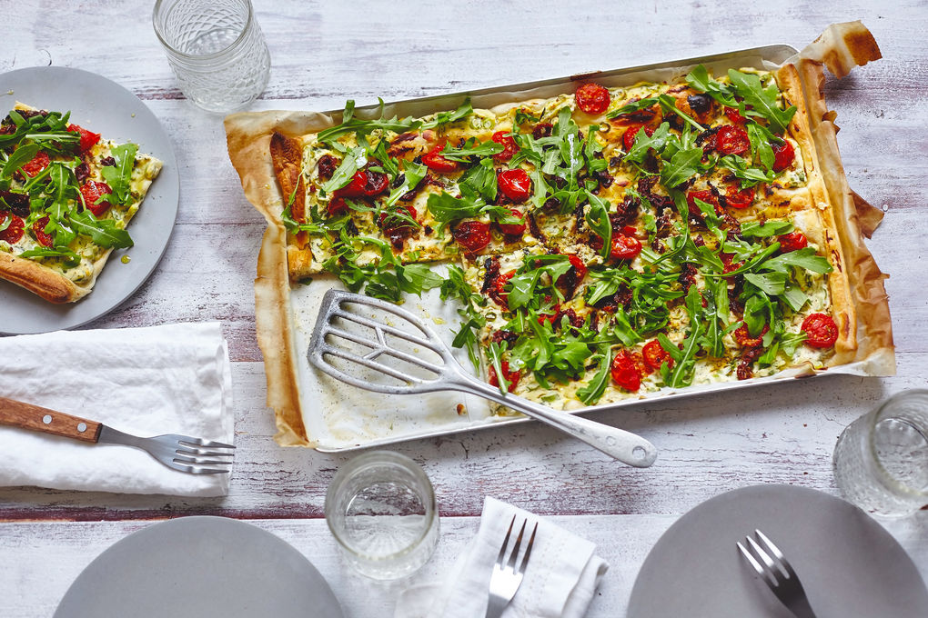 Cremige Ricotta-Tarte belegt mit Rucola und Tomaten